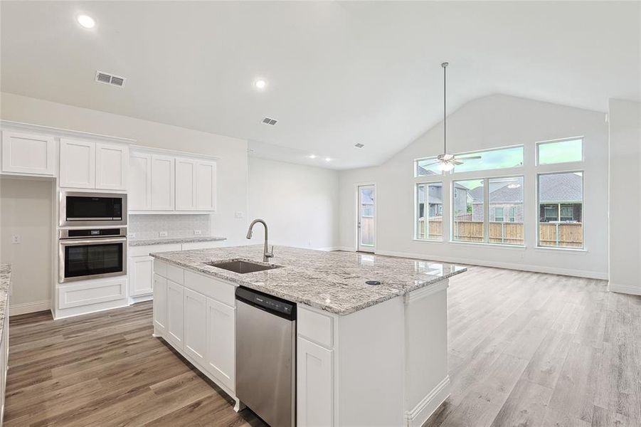 Kitchen featuring sink, light hardwood / wood-style flooring, stainless steel appliances, and white cabinets