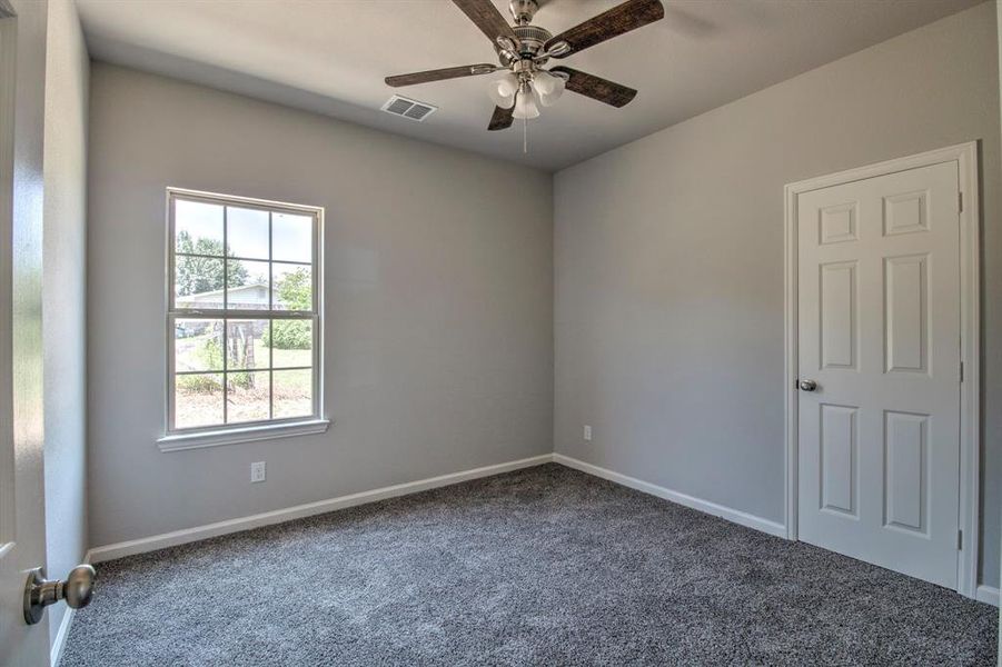 Unfurnished room featuring ceiling fan and carpet flooring