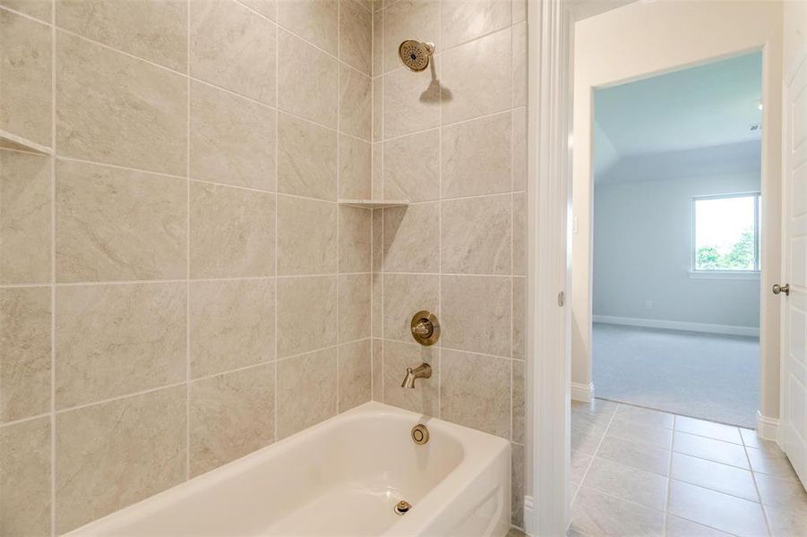 Bathroom with tile patterned flooring and tiled shower / bath combo