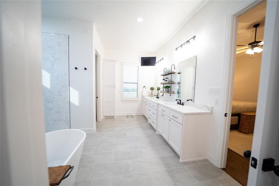 Bathroom with tile patterned flooring, a washtub, vanity, and ceiling fan