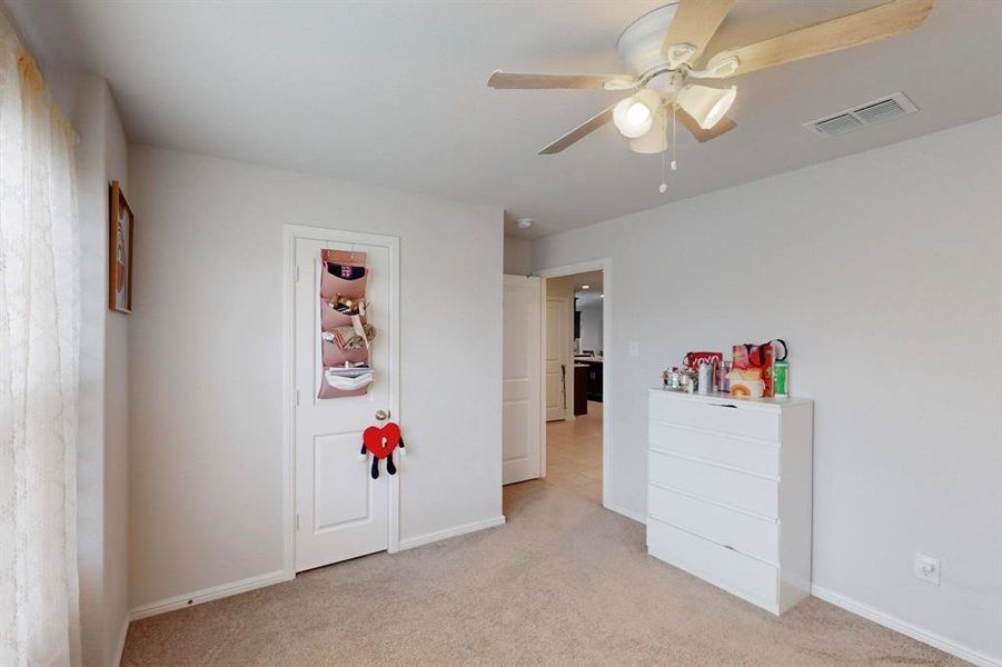 Unfurnished bedroom with ceiling fan and light colored carpet