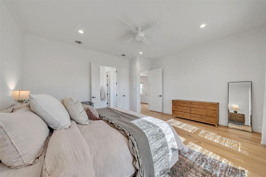 Primary Bedroom with hardwood / wood-style floors, ceiling fan, and ornamental molding