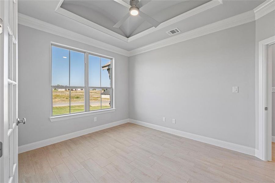 Office featuring ceiling fan, a raised ceiling, and ornamental molding