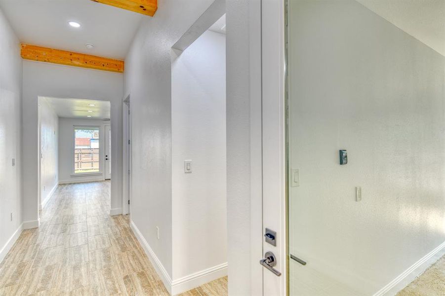 Corridor featuring light hardwood / wood-style floors and beamed ceiling