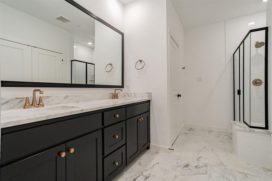Bathroom with a shower with shower door, tile patterned floors, and dual bowl vanity
