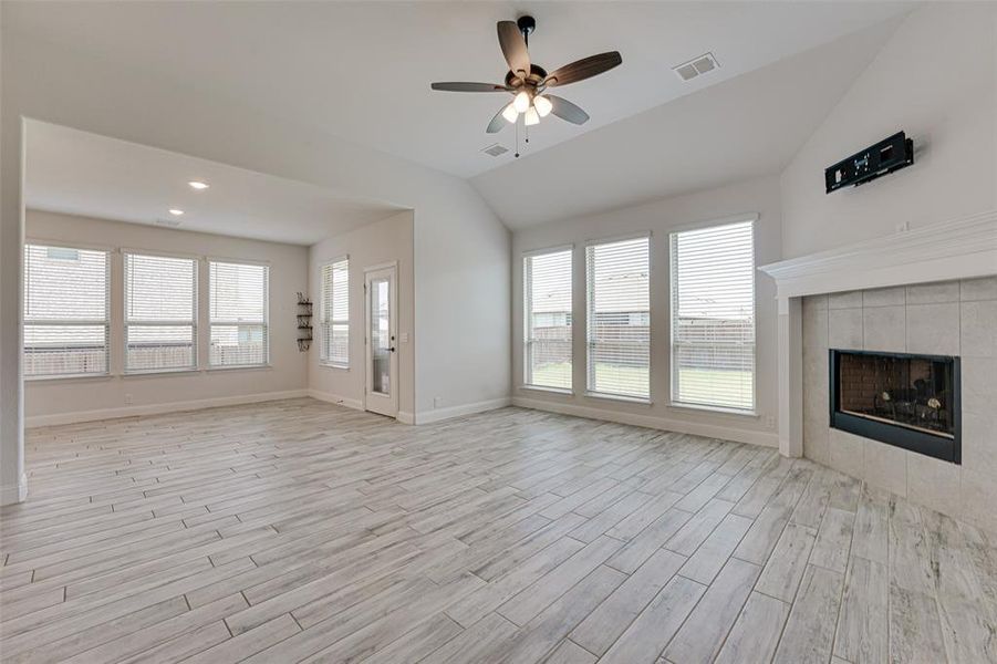 Unfurnished living room featuring a wealth of natural light, ceiling fan, and light hardwood / wood-style floors