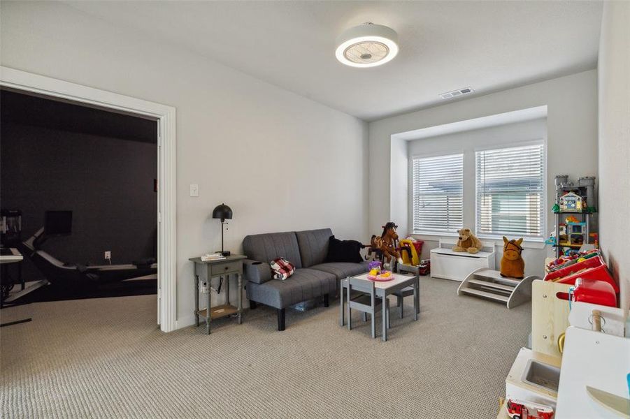 Gameroom up with no blade exposure ceiling fan and textured upgraded carpeting.