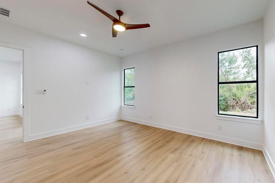 Unfurnished room with light wood-type flooring, a healthy amount of sunlight, and ceiling fan