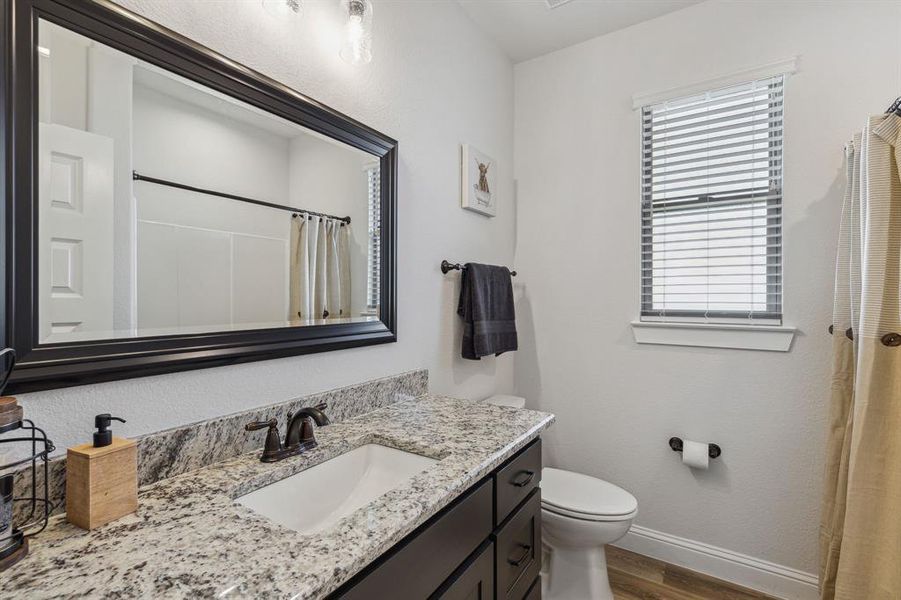 Bathroom featuring hardwood / wood-style floors, vanity, and toilet