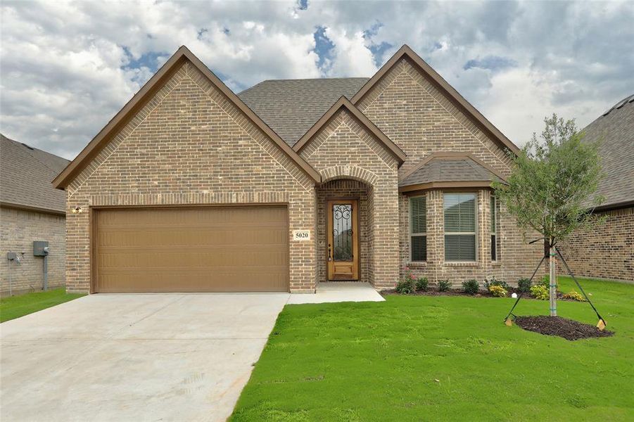 View of front of house with a garage and a front yard