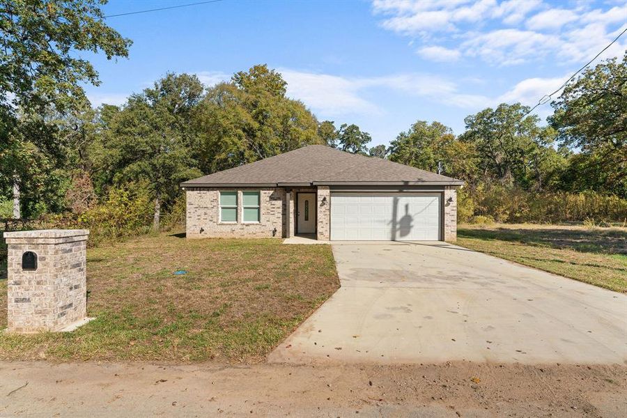 View of front of home featuring a front lawn and a garage