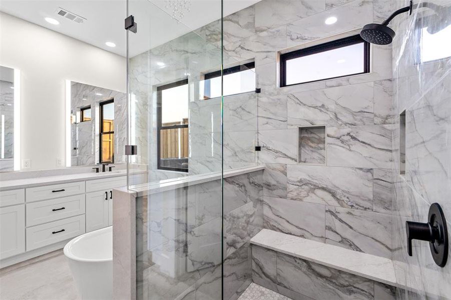 Bathroom featuring vanity, plus walk in shower, and a wealth of natural light