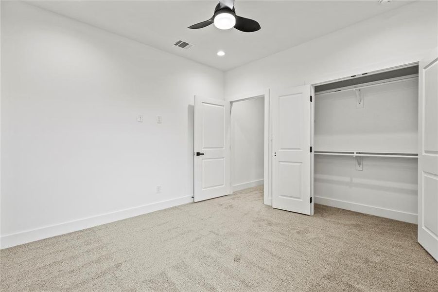 Unfurnished bedroom with light colored carpet, a closet, and ceiling fan