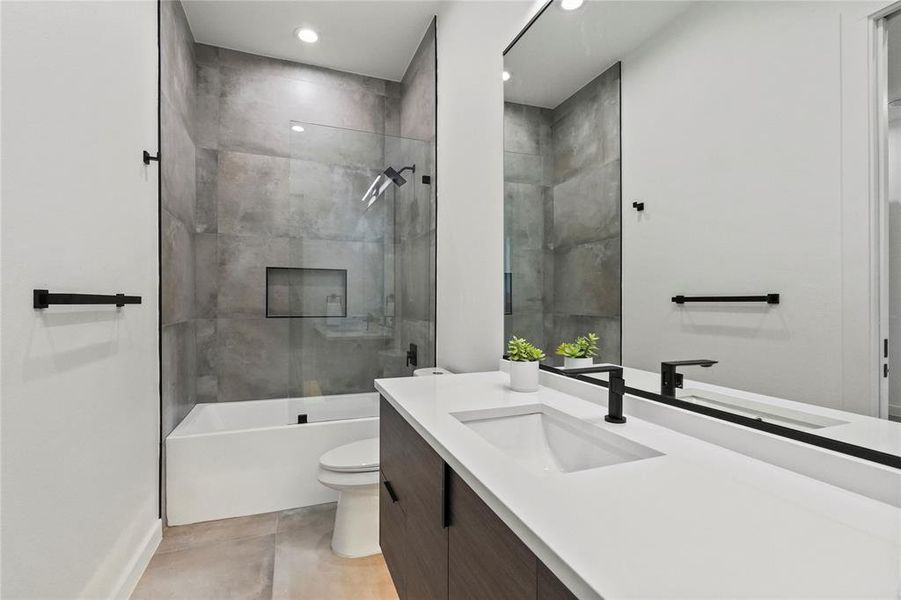 Full bathroom with vanity, toilet, and tiled shower / bath combo