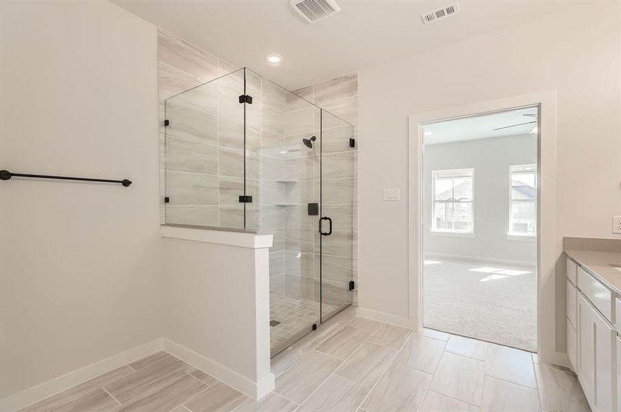 Bathroom featuring a shower with door and vanity