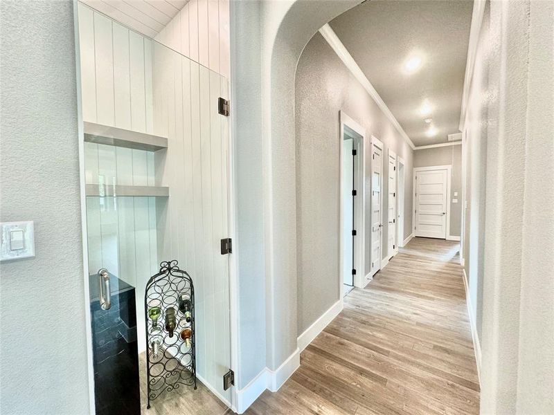 Hallway with crown molding, and light hardwood / wood-style floors