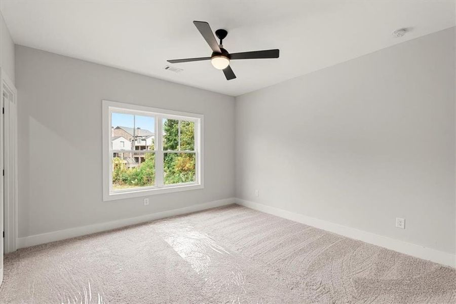 Unfurnished room featuring light carpet and ceiling fan