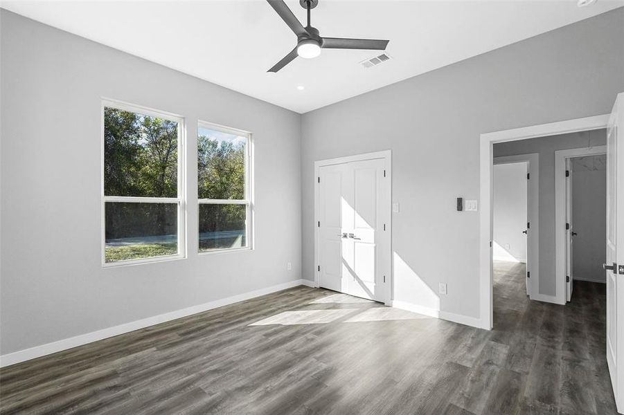 Unfurnished bedroom featuring dark hardwood / wood-style flooring, ceiling fan, and a closet