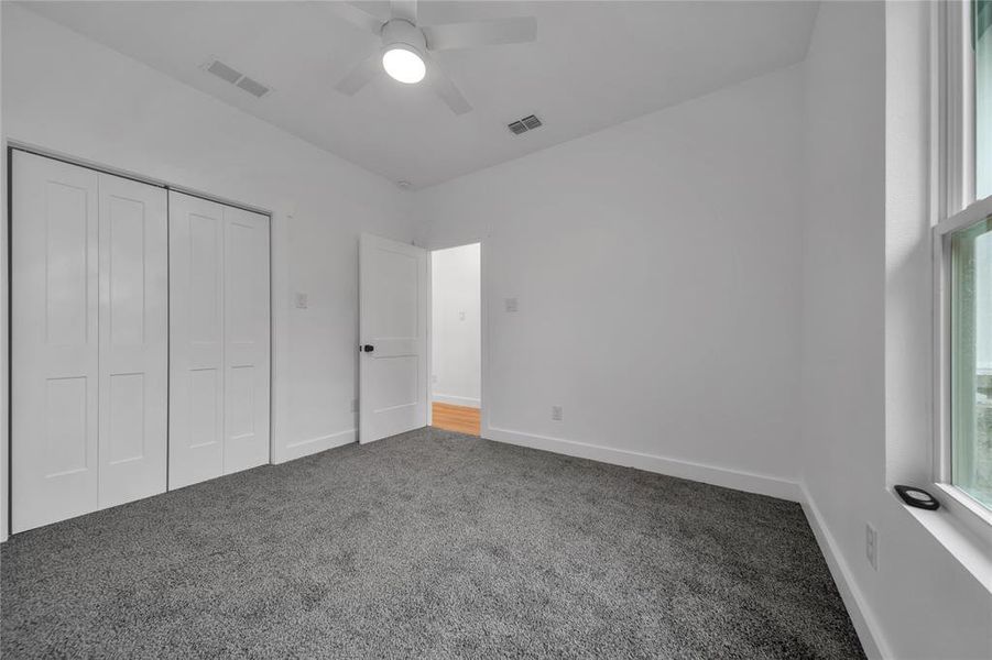 Unfurnished bedroom with ceiling fan, carpet floors, and a closet