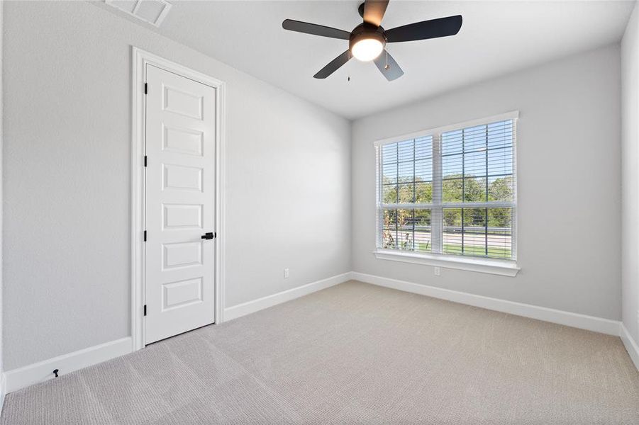 Guest bedroom include carpet and ceiling fans.