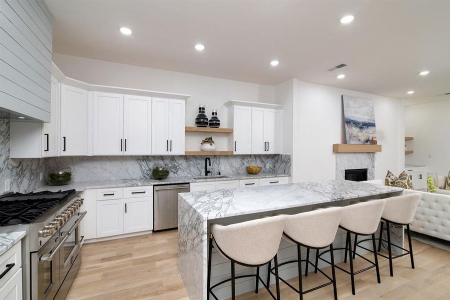 Kitchen featuring white cabinets, light wood-type flooring, appliances with stainless steel finishes, and sink