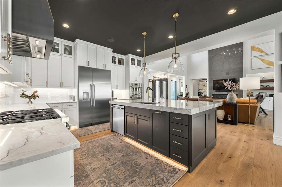 Kitchen Thermador cooktop offers 6 burners.  Open floorplan with Restoration Hardware light fixtures throughout.