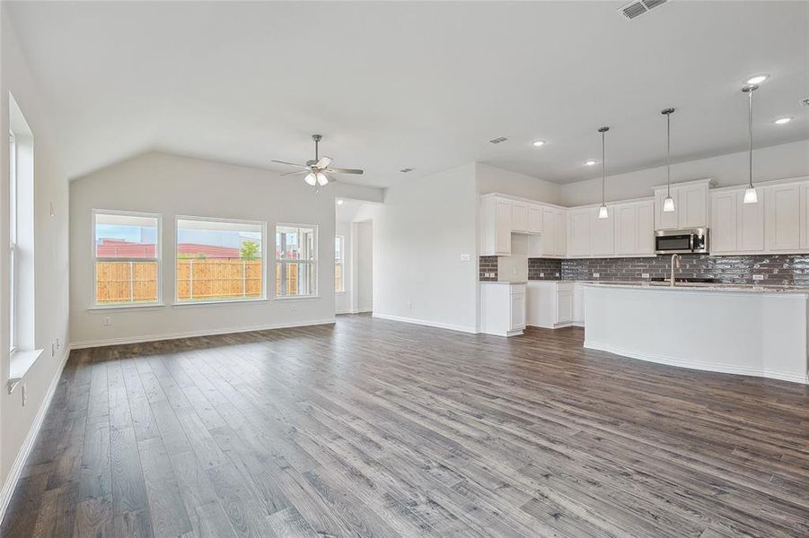 Unfurnished living room featuring ceiling fan, dark hardwood / wood-style floors, and sink