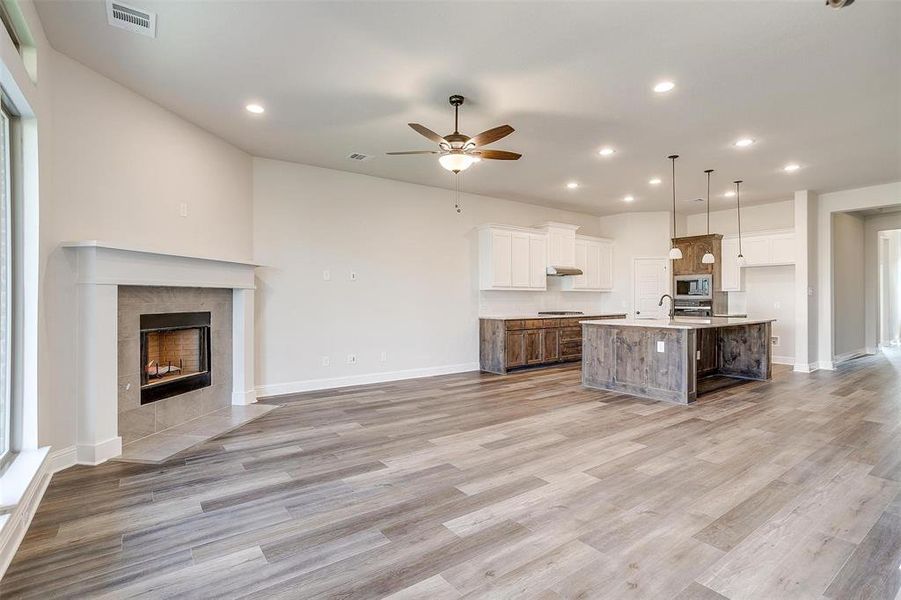 Kitchen featuring appliances with stainless steel finishes, white cabinetry, ceiling fan, and a spacious island