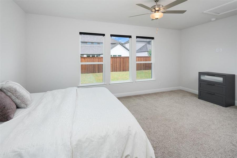 Bedroom with light colored carpet and ceiling fan