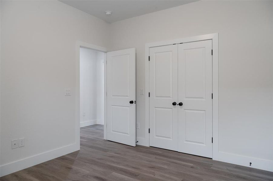 Unfurnished bedroom with hardwood / wood-style flooring and a closet