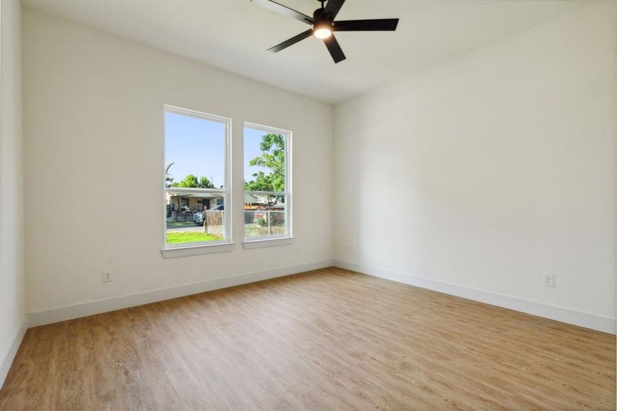 Empty room with ceiling fan and light hardwood / wood-style floors