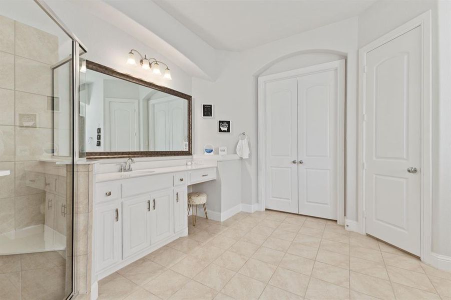 Bathroom with tile floors, an enclosed shower, and vanity
