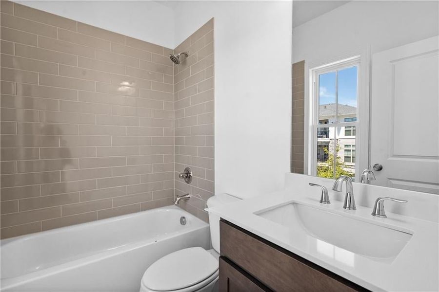 Full bathroom with vanity, tiled shower / bath combo, and a wealth of natural light
Pictures represent a previously built home