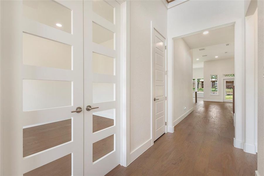 Corridor featuring dark hardwood / wood-style floors and french doors