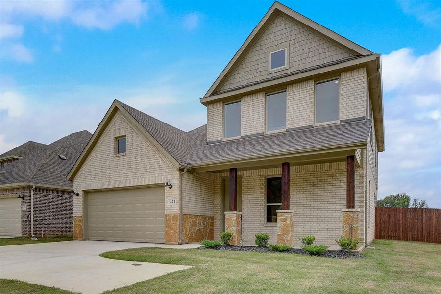 Craftsman house with covered porch, a garage, and a front lawn