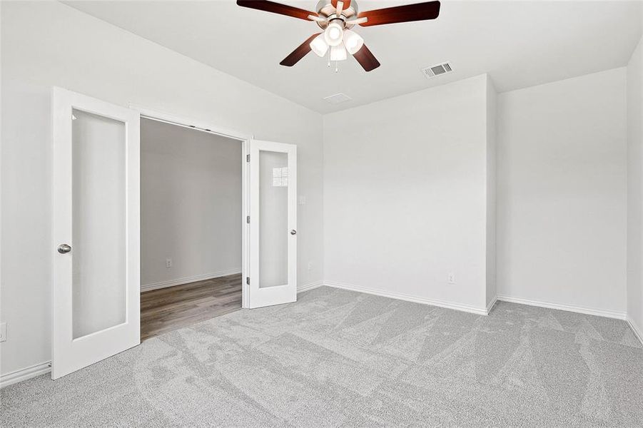 Carpeted spare room with ceiling fan