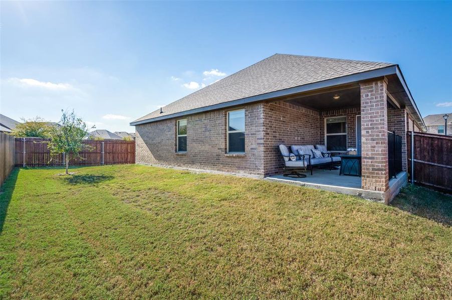 Rear view of house with a patio area and a lawn