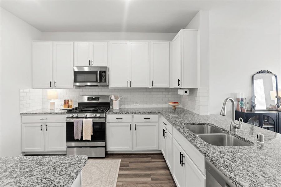 Featuring sleek stainless steel appliances complemented by a chic subway tile backsplash, this kitchen embodies modern elegance with top-notch upgrades.