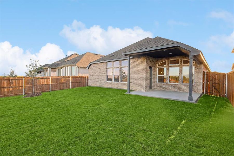 Rear view of property with a patio and a yard