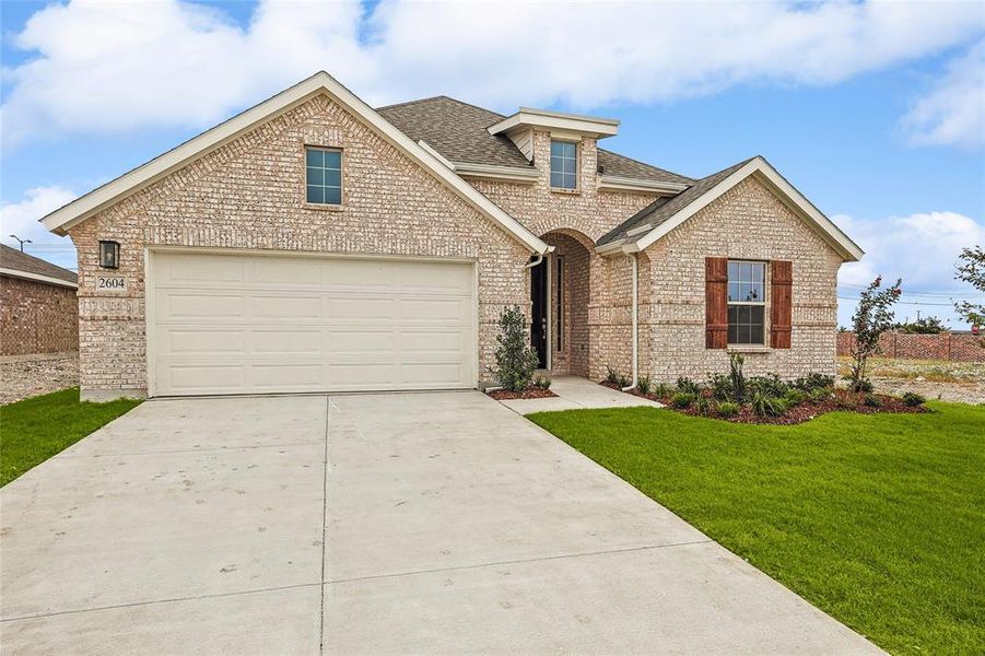 View of front of home featuring a garage and a front yard