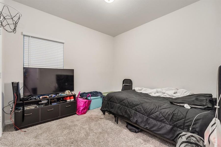 Bedroom featuring light carpet