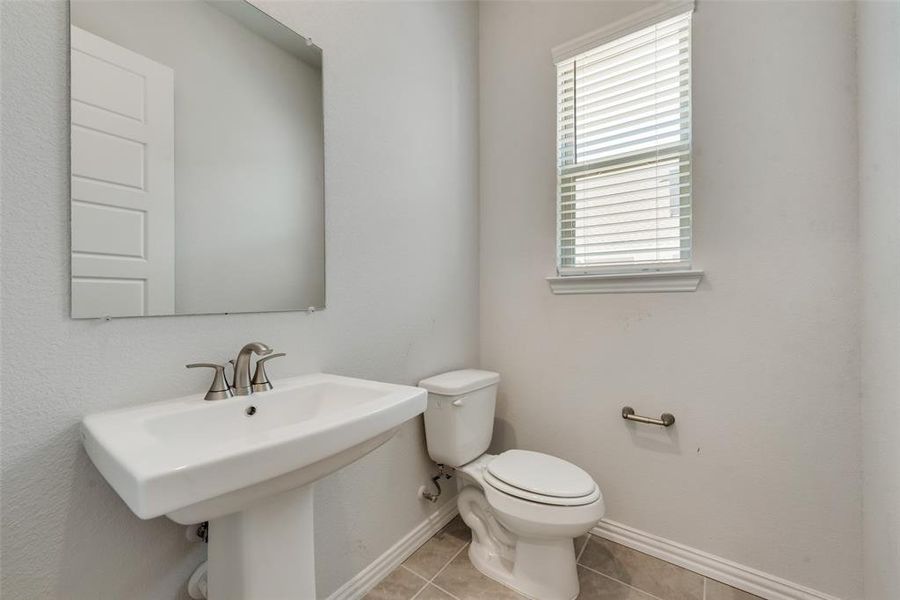 Bathroom featuring tile patterned floors, toilet, and sink