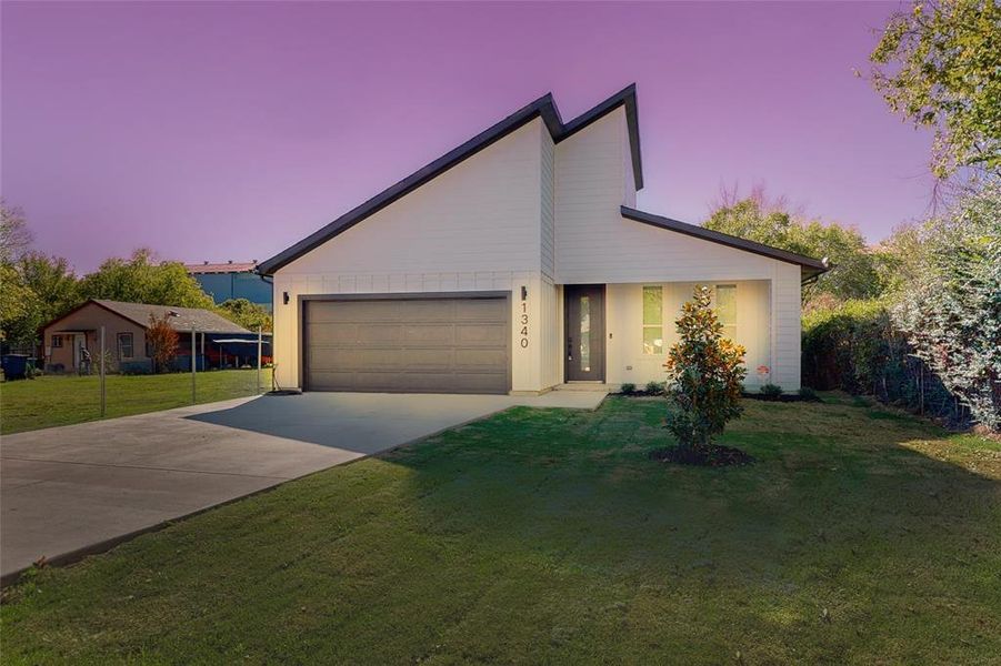 View of front of home with a yard and a garage