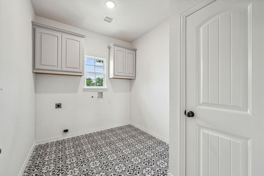 Laundry area featuring electric dryer hookup, cabinets, tile patterned flooring, and washer hookup