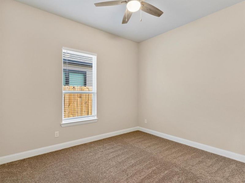 Empty room with ceiling fan and carpet floors