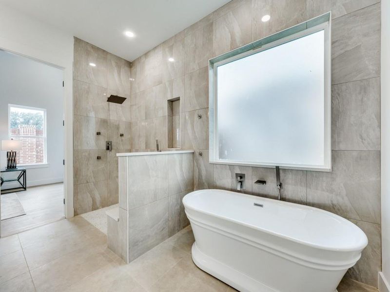 Bathroom with tile patterned floors, shower with separate bathtub, and tile walls