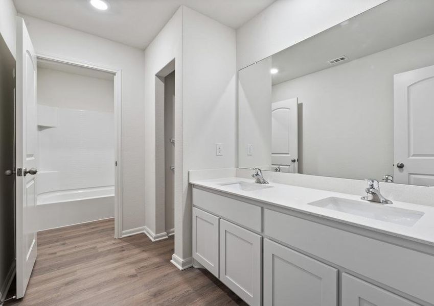 The secondary bathroom of the Driftwood has a large vanity with dual sinks.
