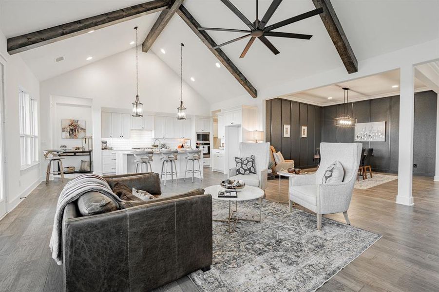 Living room featuring light hardwood / wood-style floors, beamed ceiling, sink, high vaulted ceiling, and ceiling fan