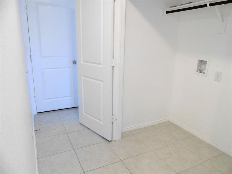 Laundry room featuring washer hookup and light tile patterned flooring