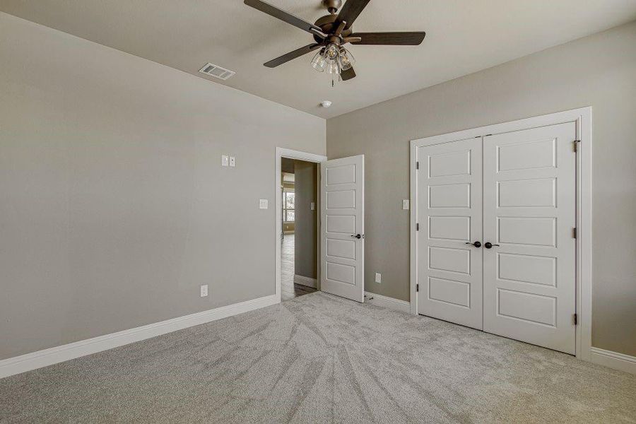 Unfurnished bedroom featuring a closet, ceiling fan, and light carpet